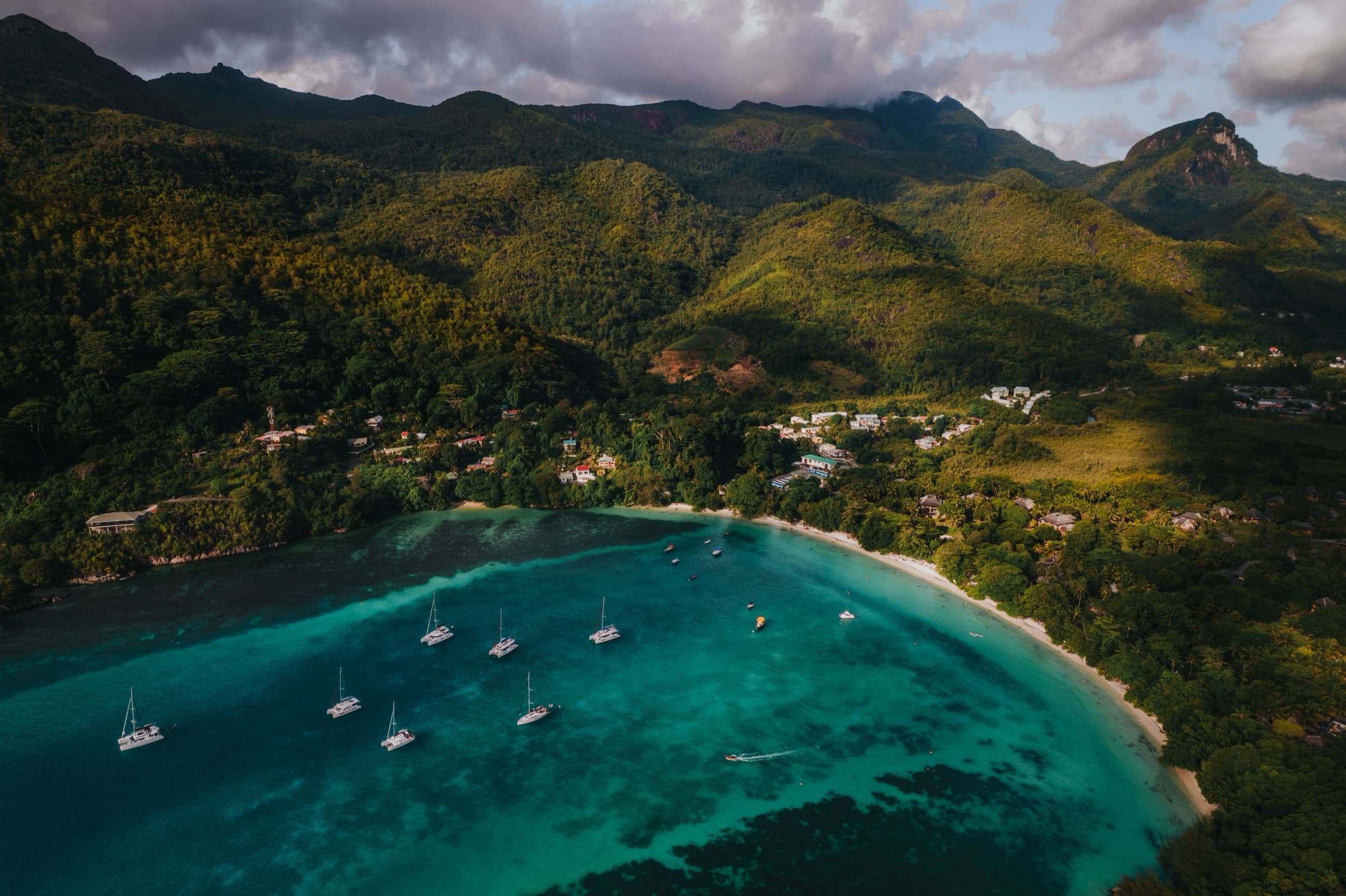 Catamarans anchored in Beau Vallon Bay beneath the forested peaks of Mahé, Seychelles