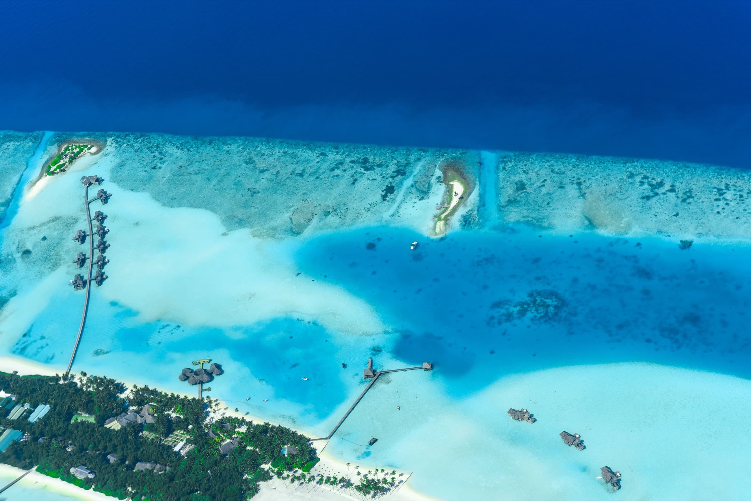 Overwater villas on stilts reaching out into a turquoise lagoon