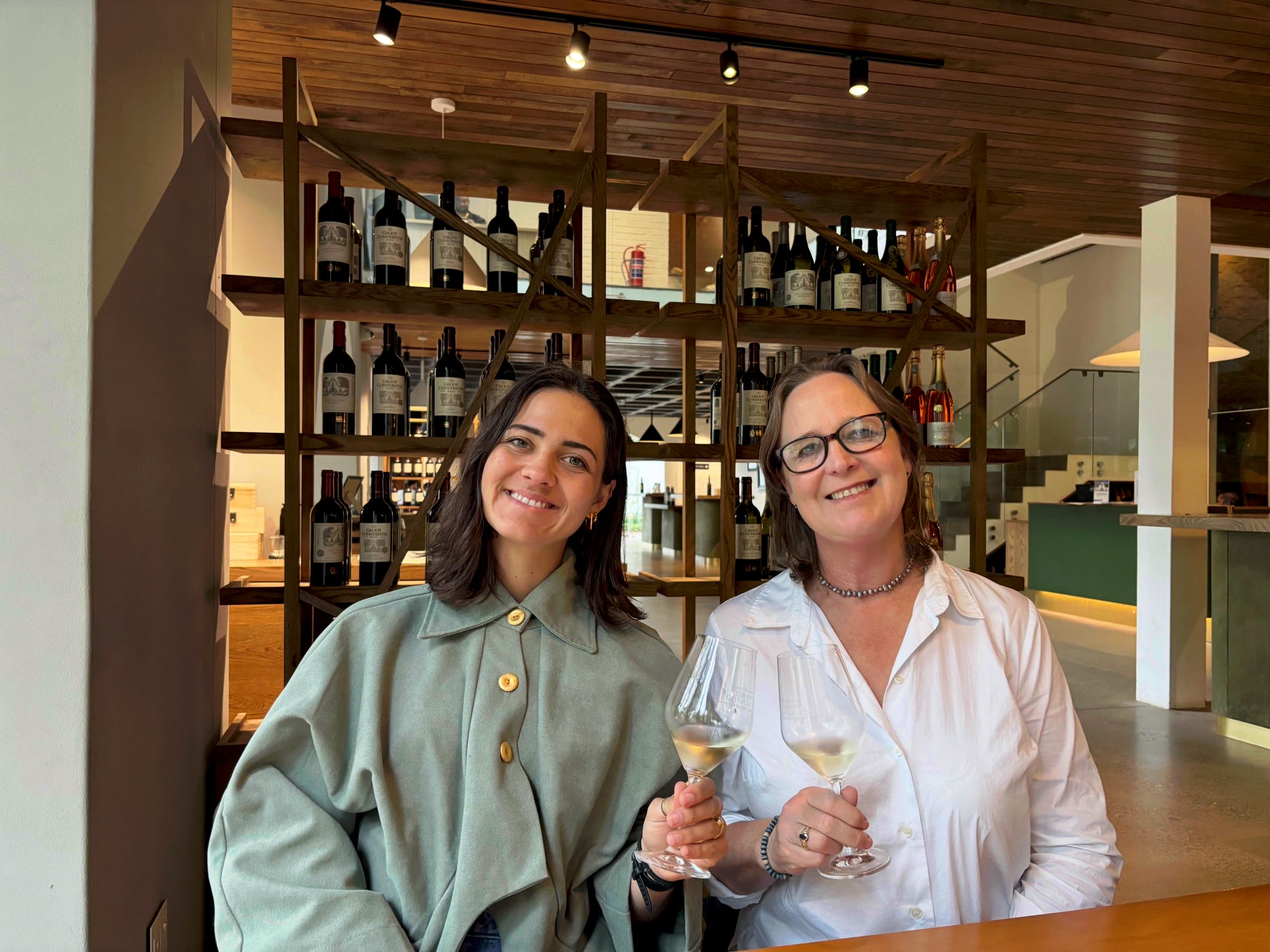 Anni Hoffmann and Ena Richards holding glasses of wine in a tasting room