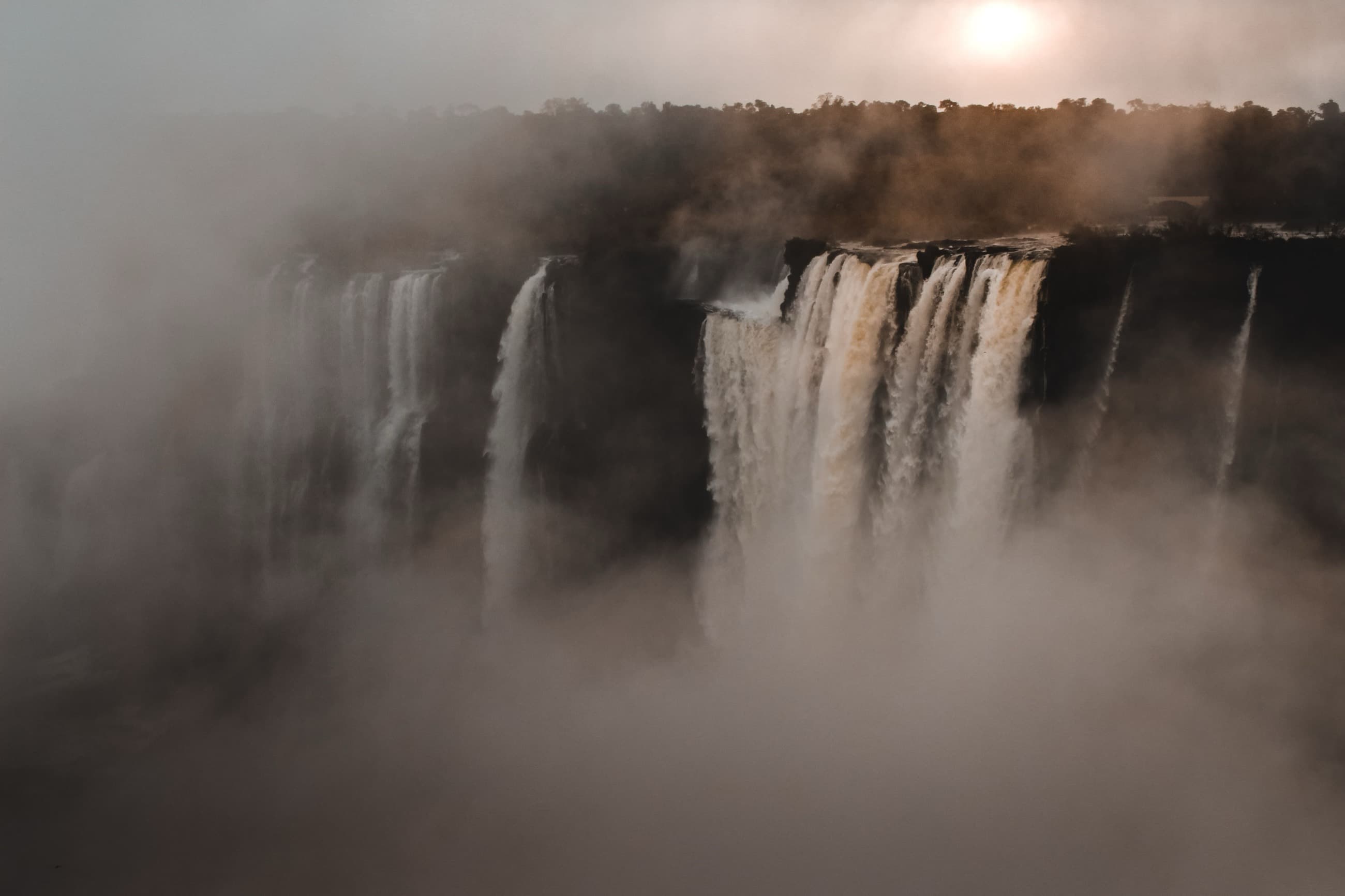 Spray rising off Victoria Falls at golden hour